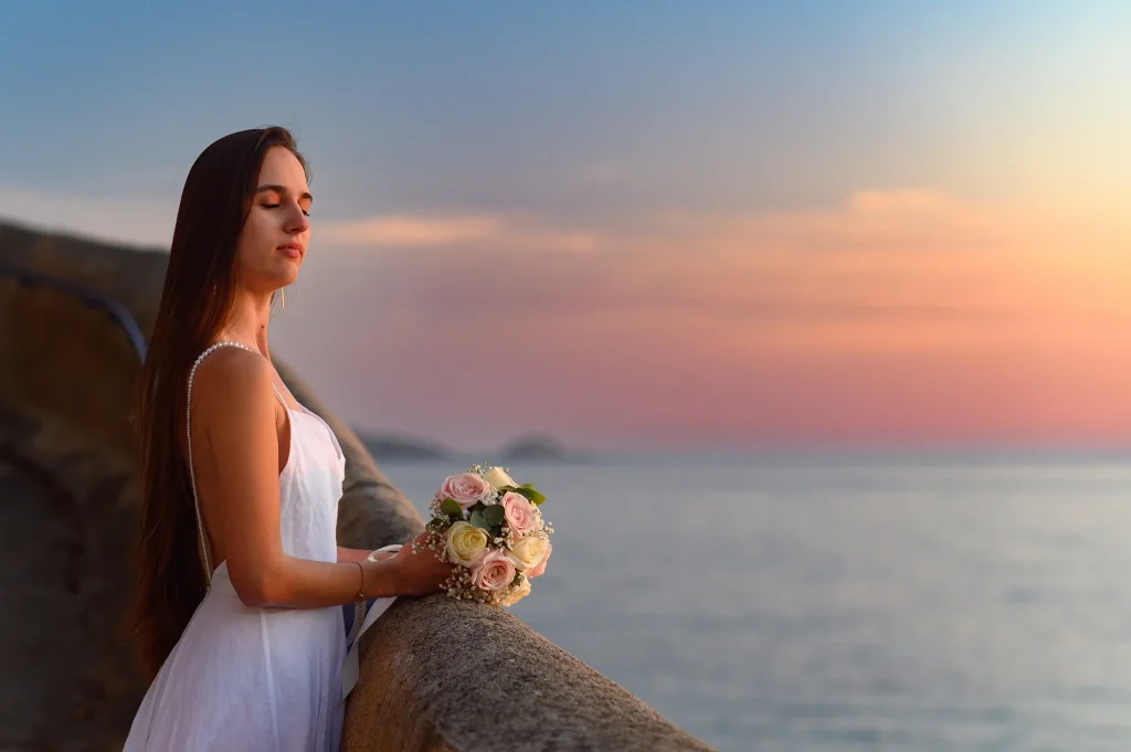 Bride holding her bouquet by the sea at sunset in Marseille, during a wedding portrait session in the South of France.