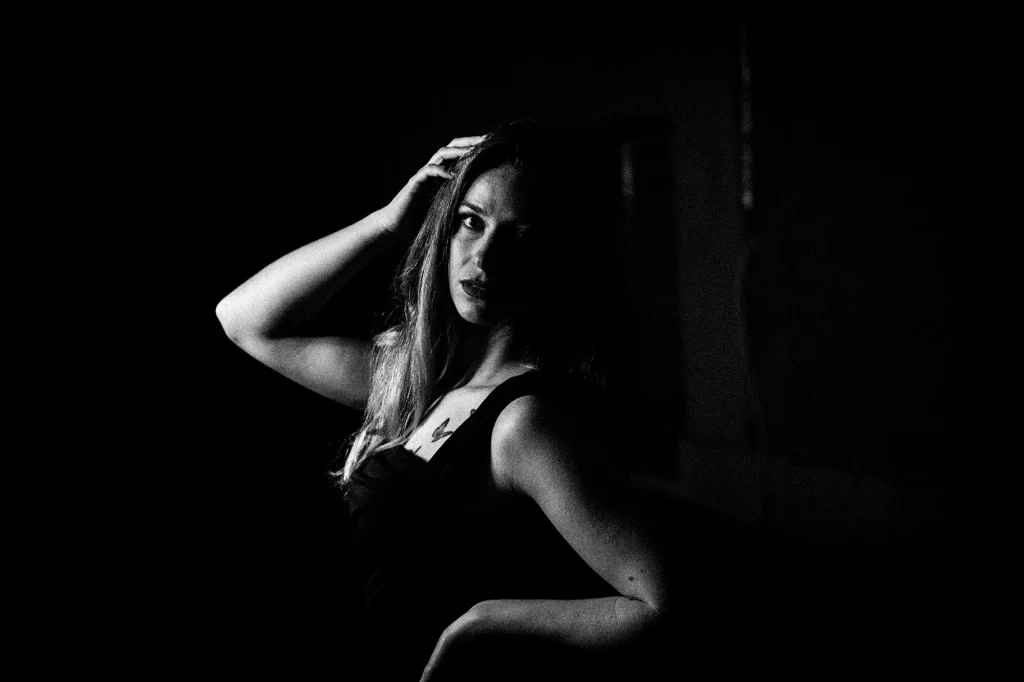 Black and white portrait of a woman with strong contrast between shadow and light