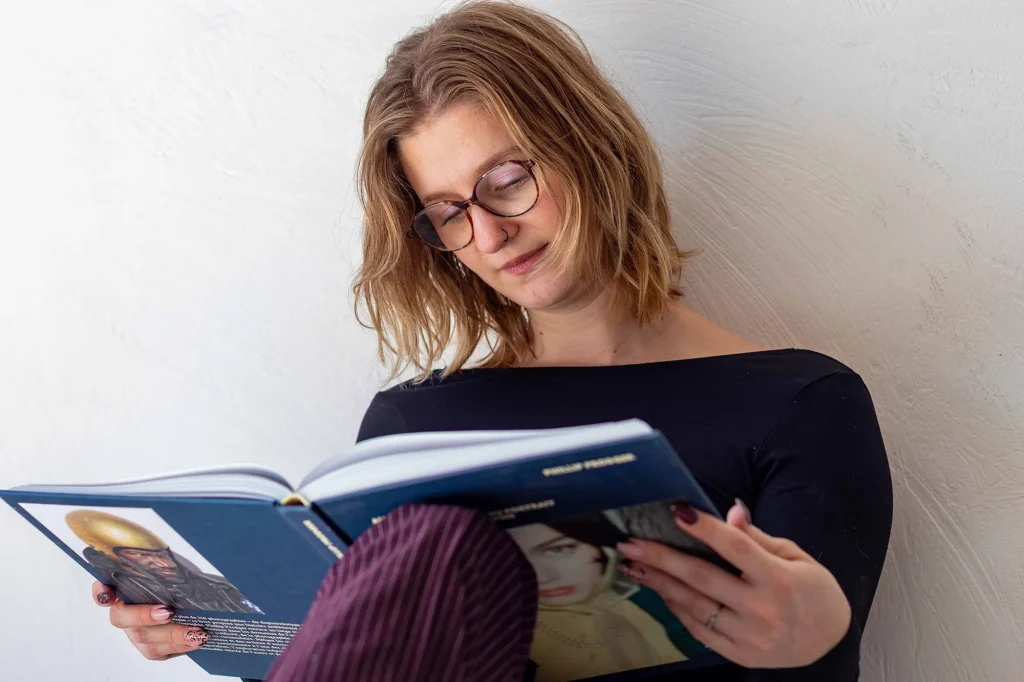 Portrait of a woman wearing glasses while reading a book in a bright interior