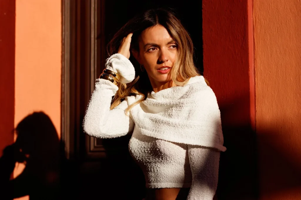 Portrait of a woman in natural light against an ochre wall, in a warm setting in Le Castellet