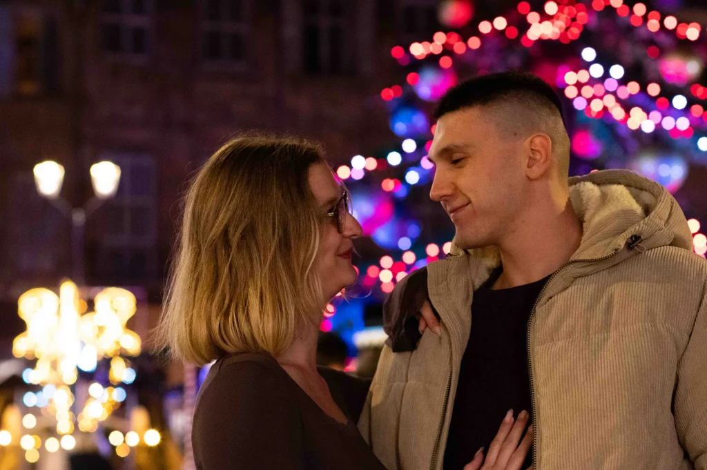 Couple se regardant pendant une séance fiançailles à Aix-en-Provence avec des lumières de Noël