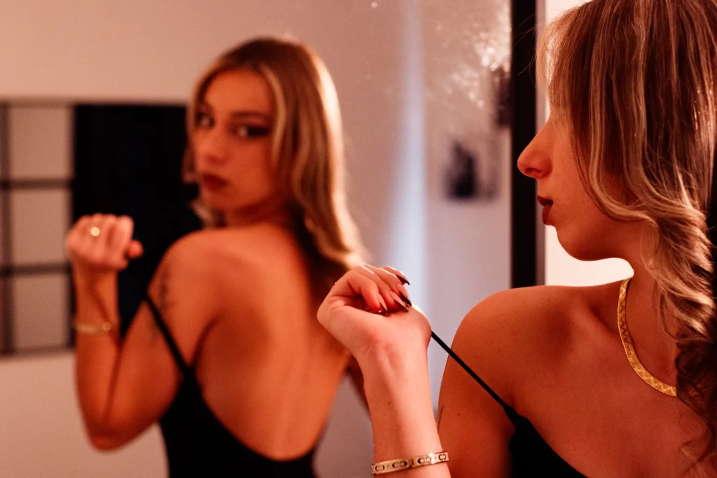 Boudoir portrait in a mirror with a black dress and suggested sensuality