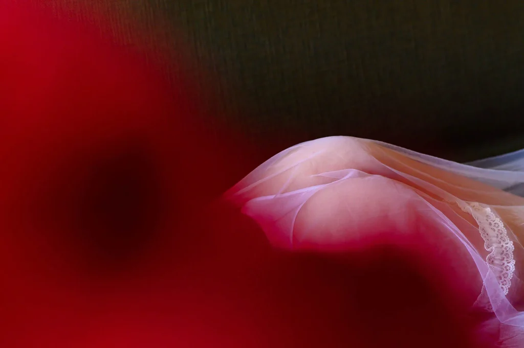 Artistic detail of a bride-to-be lying under a veil during a bridal boudoir session