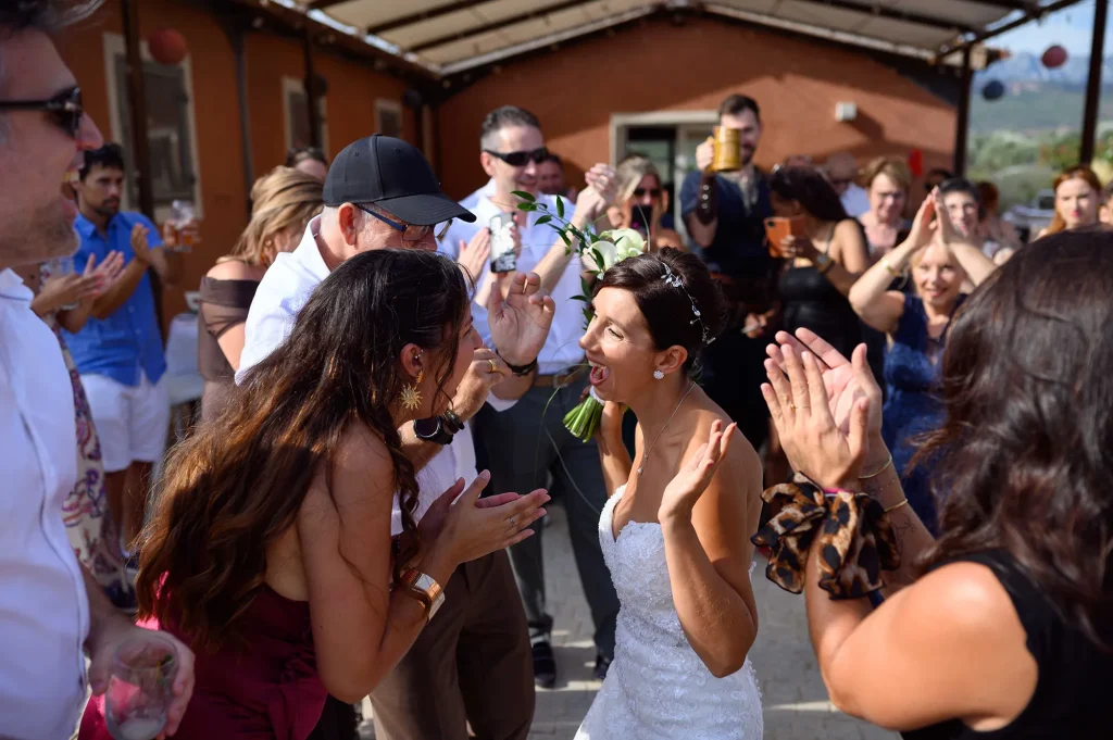 Bride surrounded by guests during a candid wedding moment in Rousset
