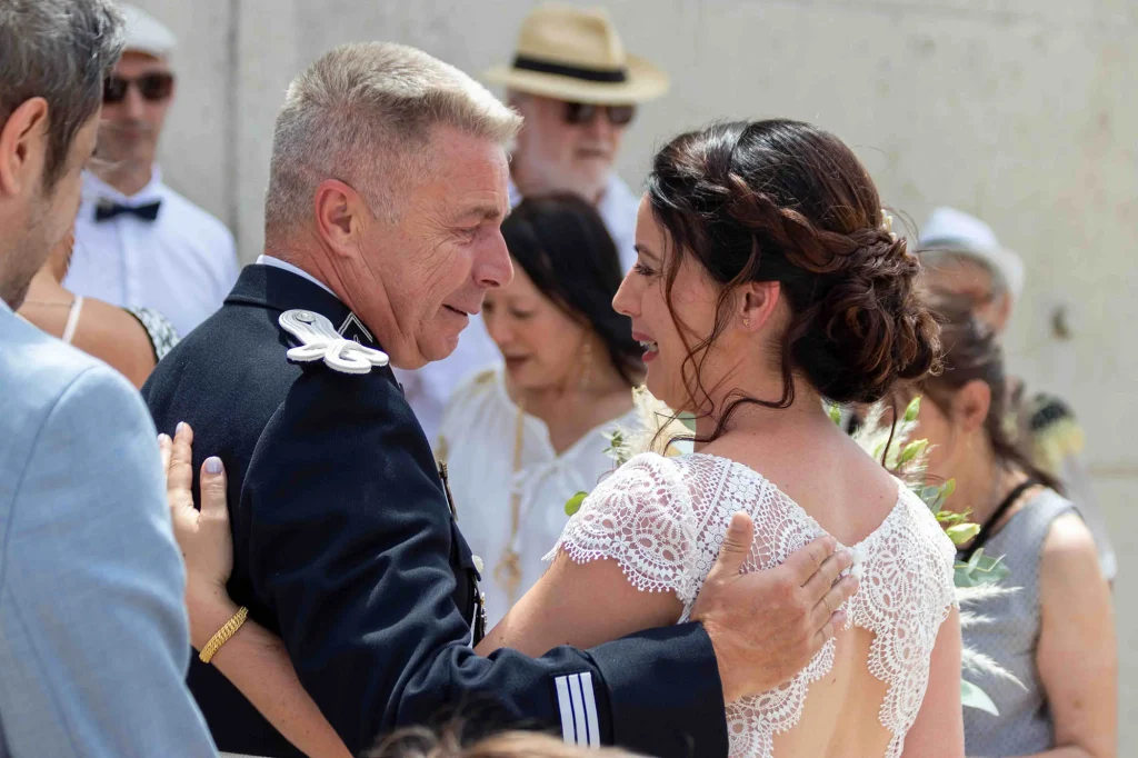 Mariée en larmes dans les bras de son père à la sortie de la mairie lors d’un mariage à Aubagne