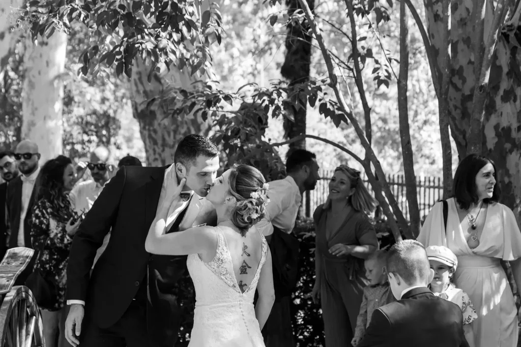 Bride and groom sharing a natural kiss outside the wedding hall in Auriol