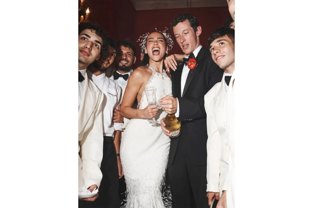 Dua Lipa and Callum Turner celebrating with friends at their wedding in Palermo, with a sparkling bridal dress and joyful atmosphere