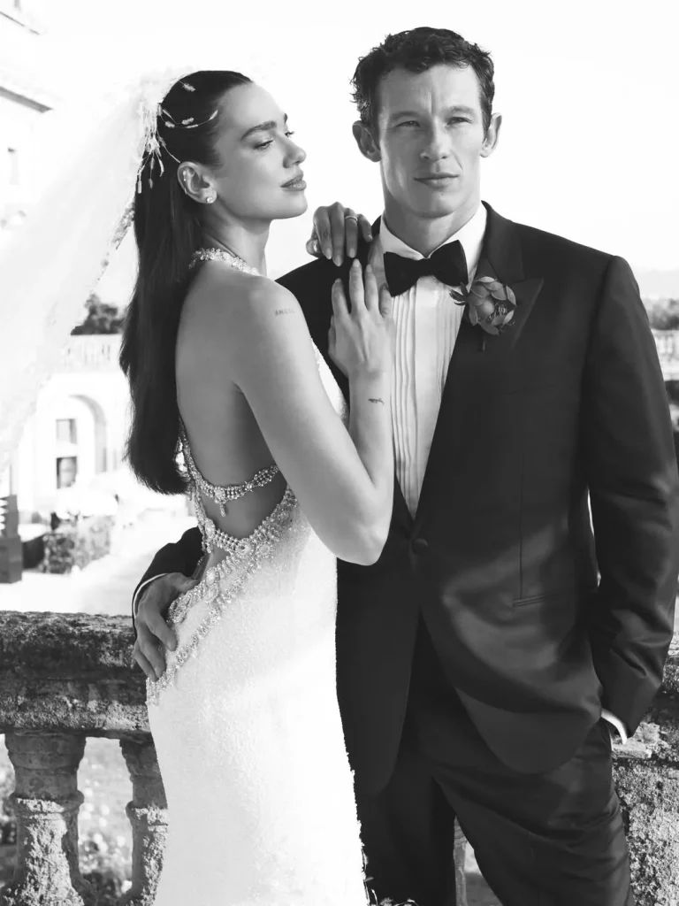 Dua Lipa and Callum Turner in an intimate pose during their Palermo wedding, with a backless dress and bow tie