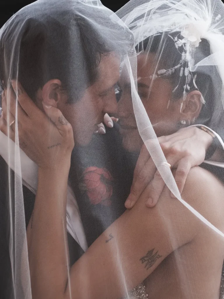 Dua Lipa and Callum Turner sharing an emotional moment under the veil during their wedding in Palermo, Sicily