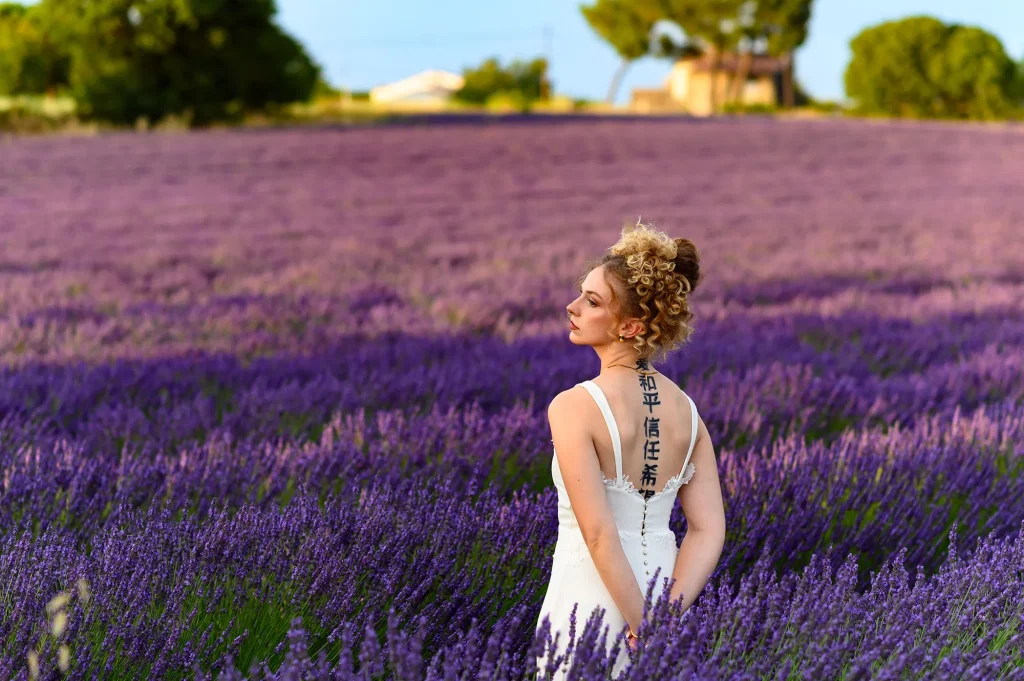 Mariée en robe blanche élégante dans un champ de lavande en Provence – photo romantique pour un photographe de mariage spécialisé en Provence