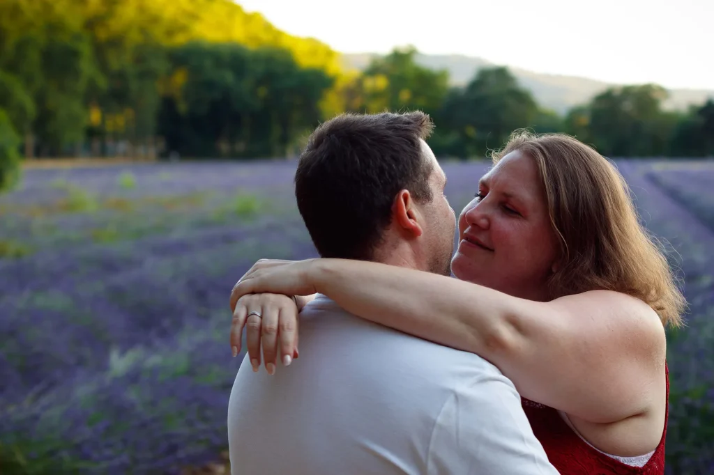 Couple s’étreignant tendrement dans un champ de lavande au Tholonet près d’Aix-en-Provence, ambiance romantique et naturelle avec des rangées de lavande en arrière-plan