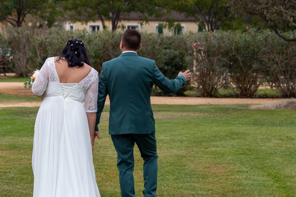 Newlyweds walking confidently through the garden at their wedding venue in Eyragues
